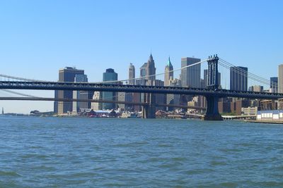 Manhattan bridge over east river against clear sky in city