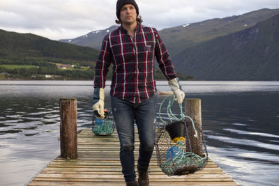 An out of focus shot of a fisherman carrying a crab pot to be repaired