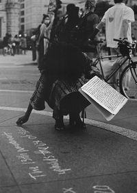 Low section of people walking on road in city