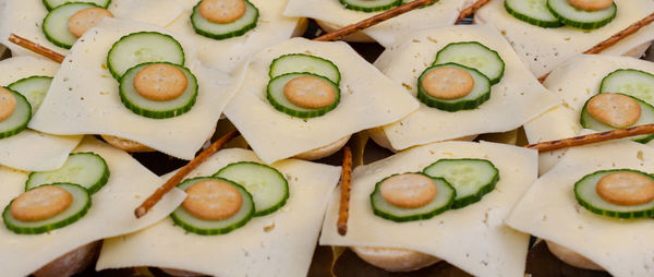 Bread rolls with slices of cheese served with sliced cucumber