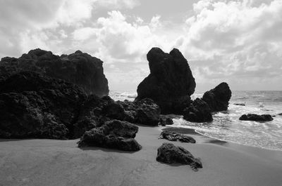 Rocks on sea shore against sky