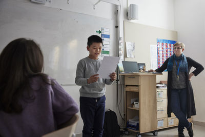 Boy reading in front of class