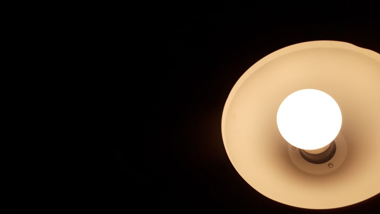 CLOSE-UP OF ILLUMINATED LIGHT BULB IN DARK