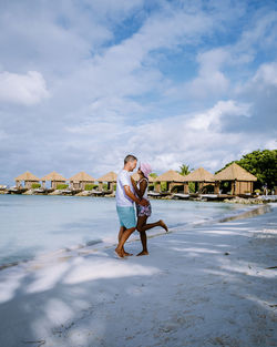 Full length of man standing on beach against sky