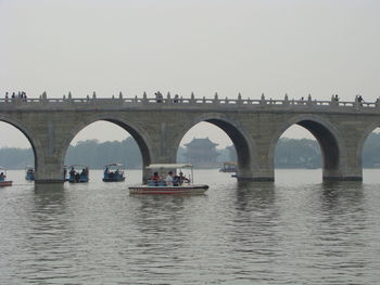 Arch bridge over river against sky