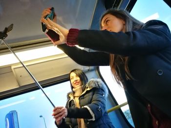 Young woman taking selfie in bus