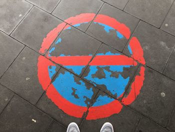 Low section of person standing on street by sign