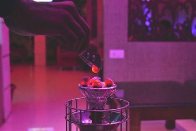 Cropped image of hand keeping coal on hookah at restaurant