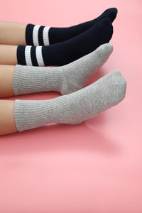 Low section of children wearing socks while resting over colored background