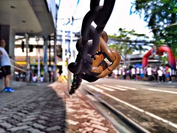 Close-up of metal hanging against the sky