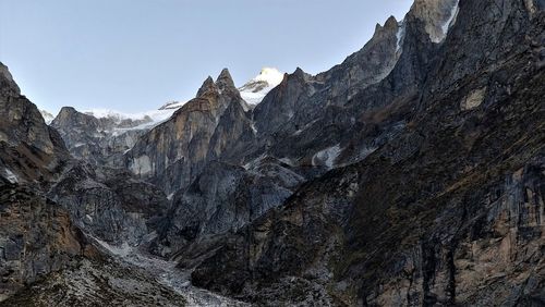 Low angle view of rocky mountains against clear sky