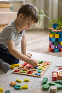 Boy playing with toy blocks at home