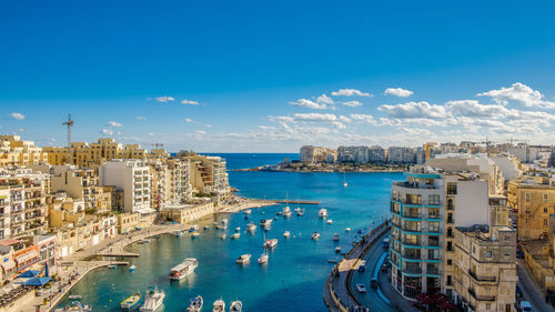 High angle view of city by sea against sky