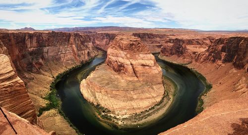 Scenic view of rock formations against cloudy sky