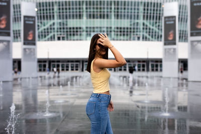 Side view of woman standing in city 