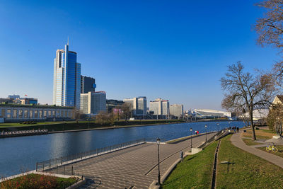 River by buildings against blue sky