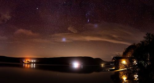 Scenic view of lake against sky at night