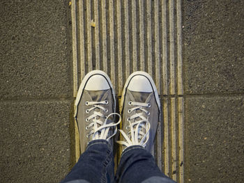 Low section of man standing on sidewalk