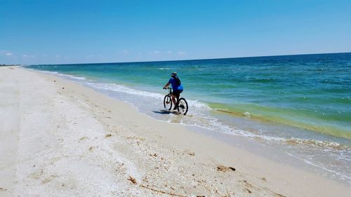 Man riding bicycle on beach