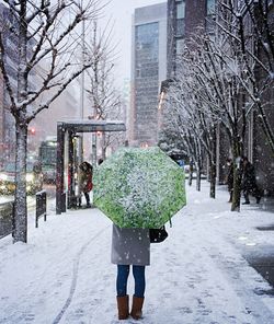 Woman walking in snow covered city