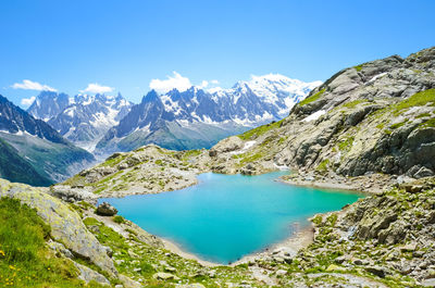 Scenic view of lake and mountains against blue sky