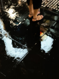 Low section of person standing in water