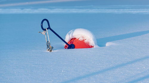 A boat buoy under the snow at a boat site in the swedish baltic sea.