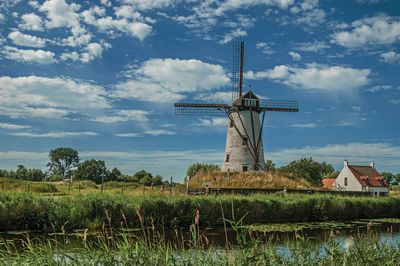 Canal with old windmill and bushes near damme. a charming country village in belgium.