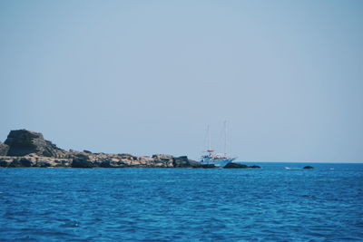 Sailboats sailing in sea against clear sky