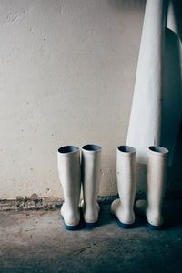 Close-up of white objects on floor against wall