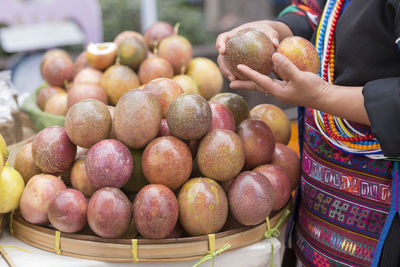 Close-up of hand holding fruits at market stall