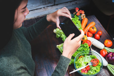 High angle view of woman holding fruit on table