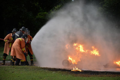 People standing by fire on bonfire