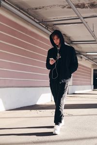 Woman listening music while walking in corridor