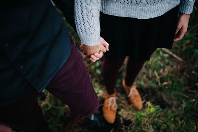 Midsection of couple on field