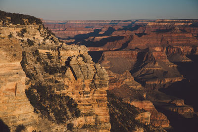 Scenic view of eroded landscape against clear sky during sunset