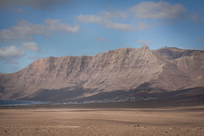 View of desert against cloudy sky