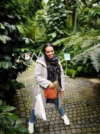 Portrait of woman standing against trees