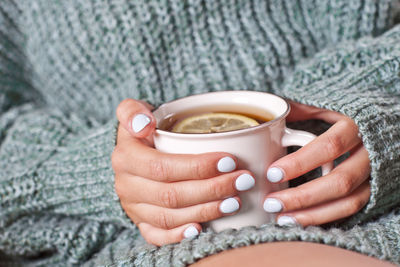 Midsection of woman holding coffee