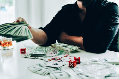 Midsection of man sitting at table