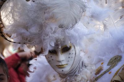 Close-up of person wearing mask and headdress