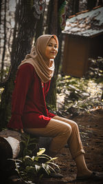 Full length of woman sitting in the forest