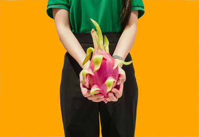 Midsection of woman holding yellow flower