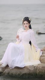 Portrait of smiling young woman standing at beach