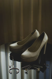 Close-up of high heels and personal accessory on chair at home