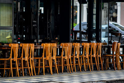 Empty chairs and tables at sidewalk cafe