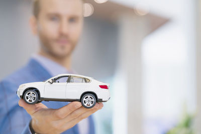 Businessman holding toy car