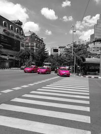 Vehicles on road against buildings in city