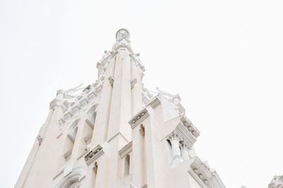 Low angle view of statue against building against clear sky