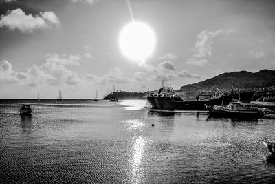 View of boats in sea against cloudy sky